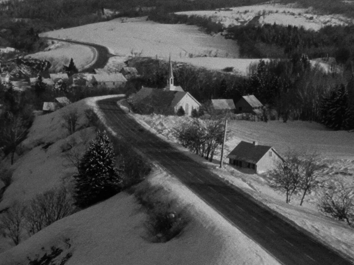 Vue aérienne d'un village enneigé et de sa route