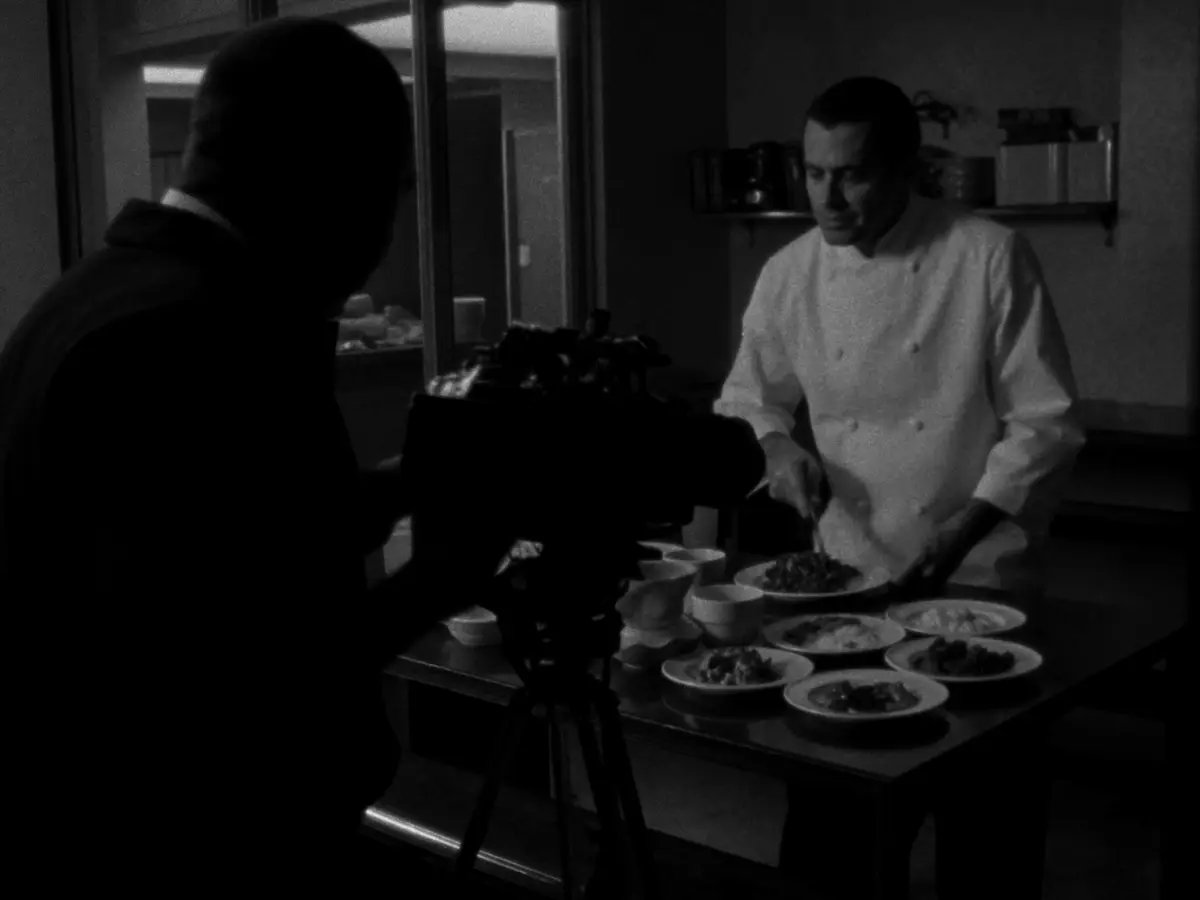 Caméraman filmant un chef qui dresse des assiettes