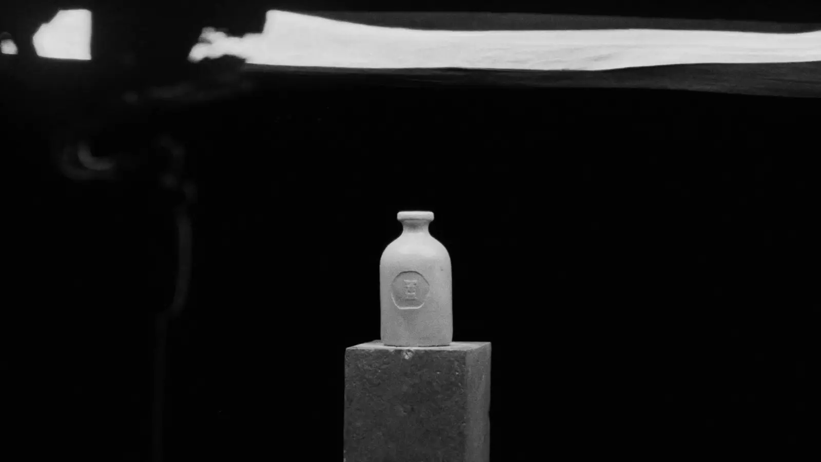 Flacon posé sur un socle, éclairage de studio