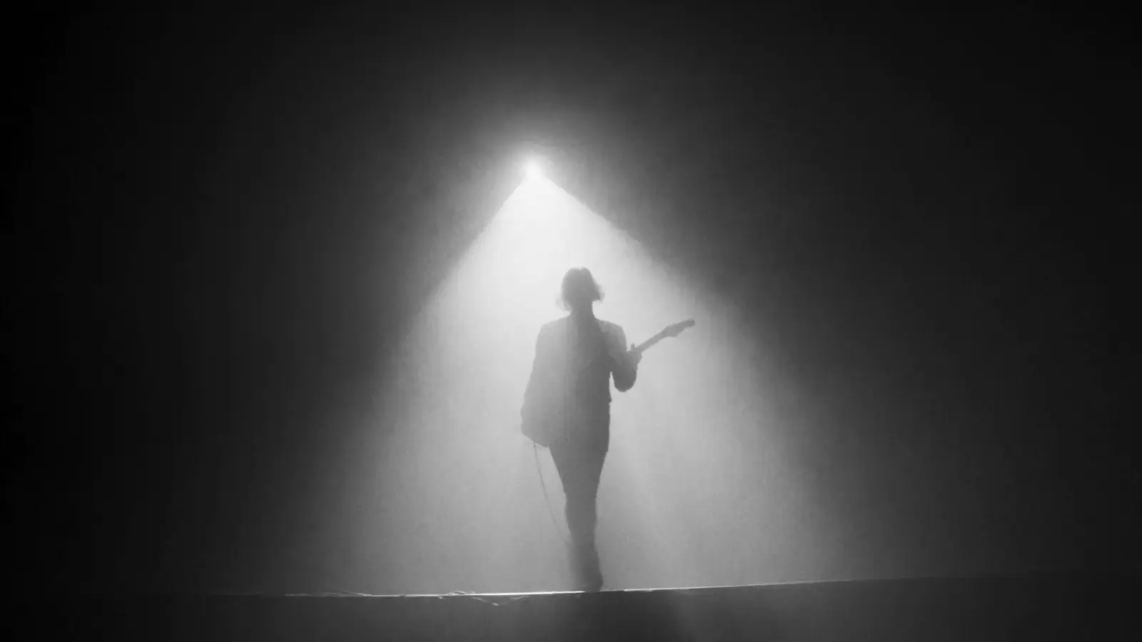 Guitariste dans un faisceau de lumière et de fumée